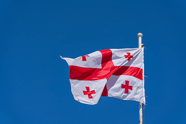 istock Georgian flag on the clear blue sky background 2254712349