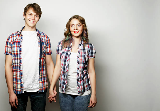 Couple in love.Young woman and man wearing casual wear over grey background.