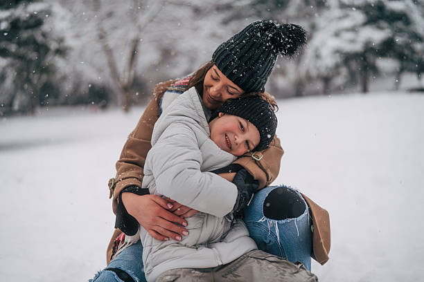 istock Mother and son hugging outdoors during winter snowfall 2254717000