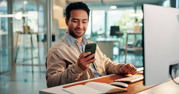 istock Design, phone and text message with business man at desk in office for development or update. App, computer and typing with designer in creative workplace for communication or online planning 2254719260