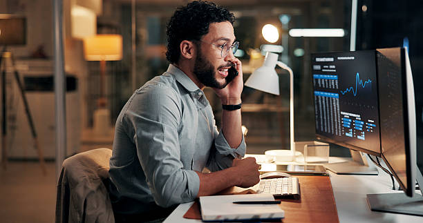 istock Evening, phone call or man with computer screen, trading or investment account with communication. Person, night or stock market analysis with pc, cellphone or stats for profit increase or discussion 2254719421