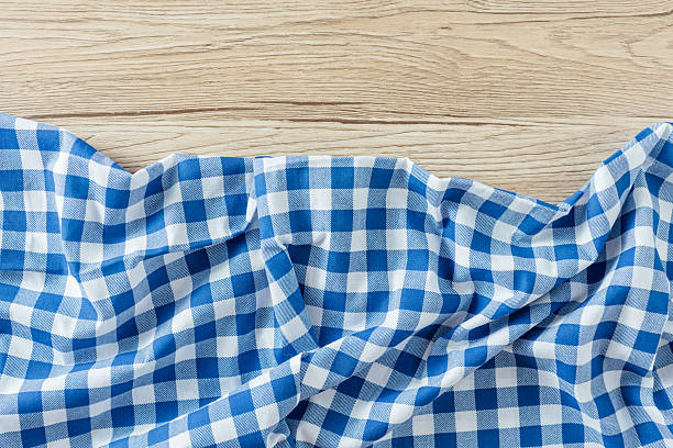 istock Blue and White Checkered Cloth on Light Wooden Surface 2254719862