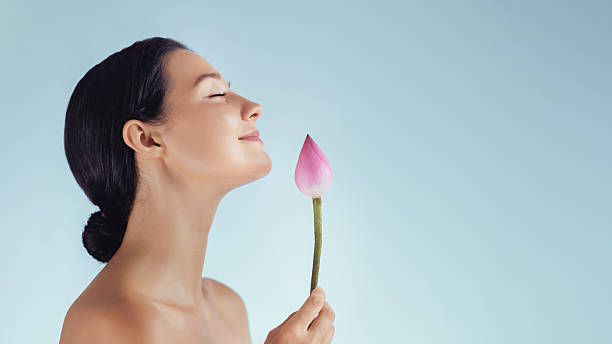 istock Smiling Woman Holding Lotus Bud on Blue Background With Space for Text 2254721035