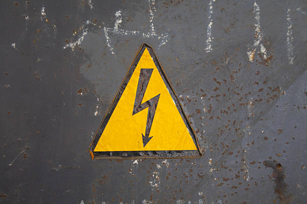 istock Yellow warning sign showing a lightning bolt placed on a rusty metal surface in an industry zone 2254724801