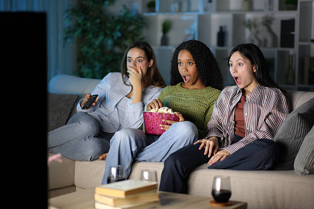 istock Amazed friends watching tv program at home in the night 2254724894