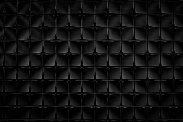 Dark black textured background of patterned wall. The pattern consists of squares and rectangles.