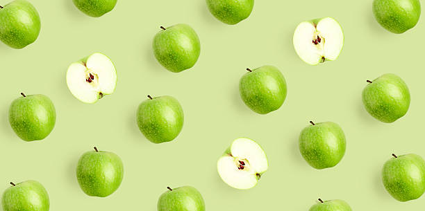 istock Green apple pattern on light green background. Repeat composition with fresh whole and sliced apples 2254729969