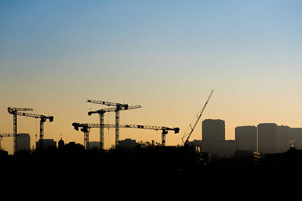 Silhouettes of construction cranes in the city of Paris