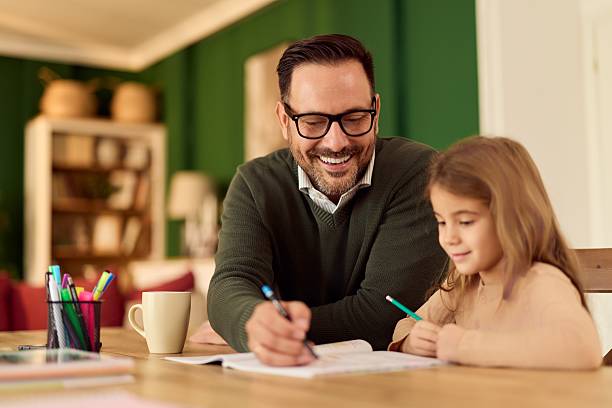istock Dad Helps Daughter With Homework At The Kitchen Table, Warm Family Learning Moment 2254731195