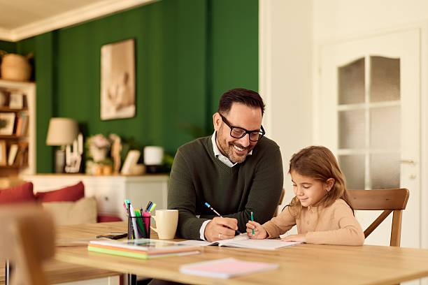 istock Dad Helps Daughter With Homework at Cozy Home Table, Learning Together 2254731202