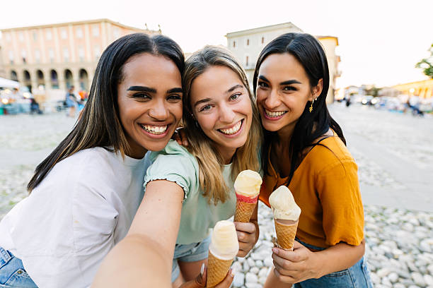 istock Three female friends eating ice cream while taking selfie during summer vacation 2254731472