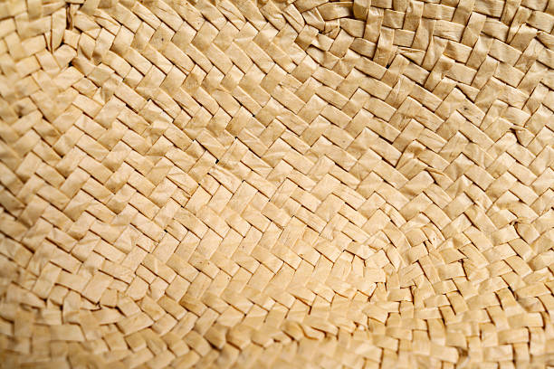 Closeup texture of a woven straw hat, perfect for use as a background in craft projects, design elements, or creative projects