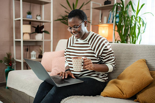 istock African American woman working from home, enjoying coffee on sofa 2254733425