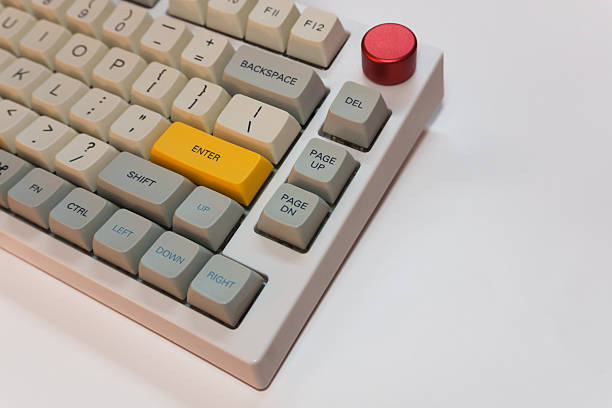 istock White mechanical keyboard with bright Enter key on white background, minimalism, keyboard buttons. A keyboard with a yellow key 2254738541