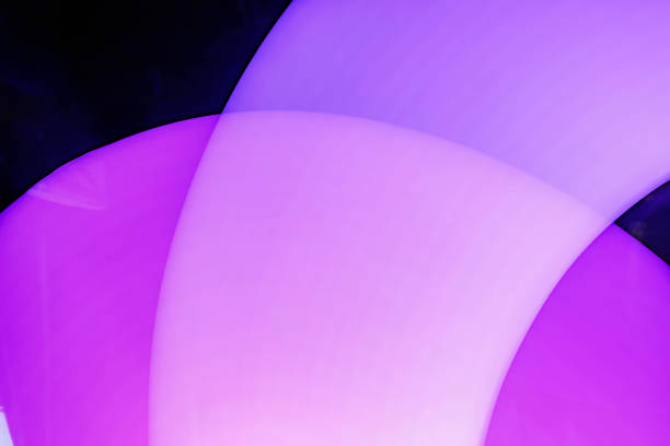 Abstract design featuring a glowing purple circle shape against a stark, dark background. The soft lighting and smooth gradients create a sense of depth and visual interest