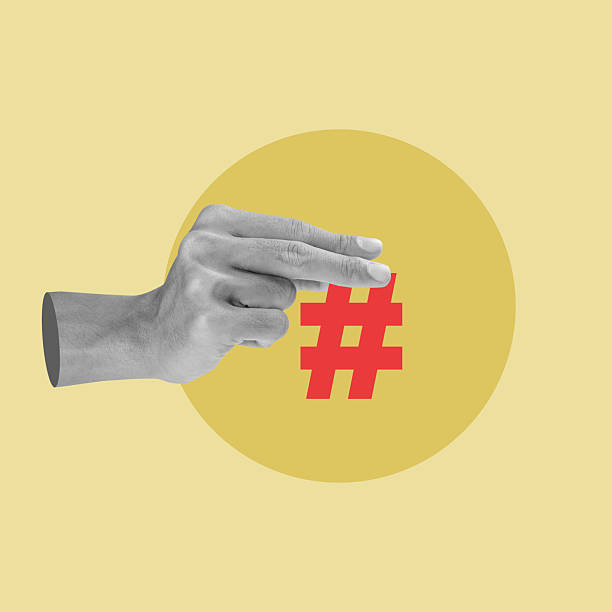 istock Grayscale hand holding a red hashtag symbol against a yellow circular background. Collage art. Concepts related to social media, technology, and trending topics 2254738793