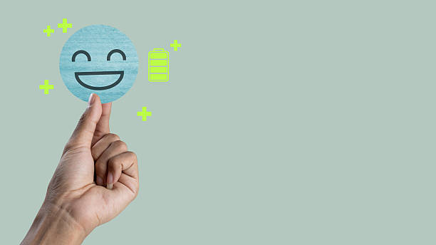 Yellow emoji with starry eyes and smiling mouth face before gray defocused background. Horizontal composition.