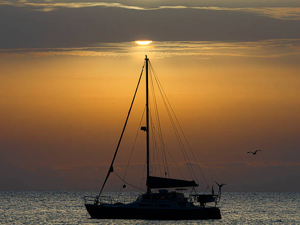 Silhouette of a sailboat at dawn