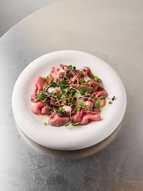 Artistic tuna carpaccio served with subtle lighting ambiance