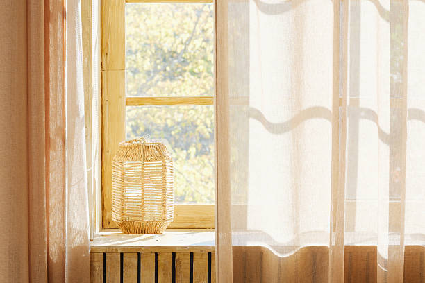 istock Wicker lantern on windowsill with sheer curtains and natural light 2254751394