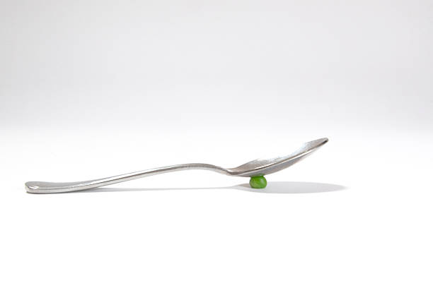 collection of iron spoons in a container with a bokeh background