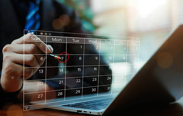 istock Business professional selecting date on digital calendar interface, marking schedule with pen over laptop, concept of appointment planning, deadline management, productivity modern business workflow. 2254753271