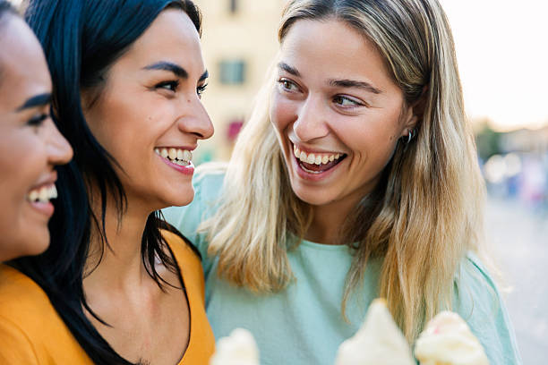 istock Young women laughing while holding ice cream cones 2254756216