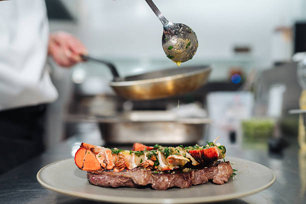 istock Souschef finishing gourmet steak plating in open kitchen 2254756744