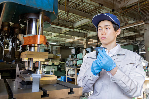 A male worker checking the dimensions of a part with a vernier caliper