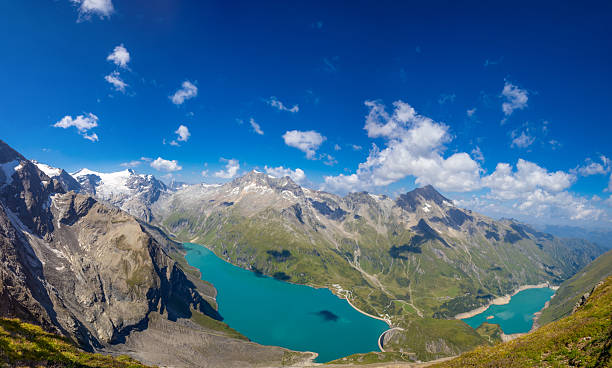 istock Austria Alps landscape with alpine meadows, forested slopes, and rugged mountain peaks under open sky 2254762066
