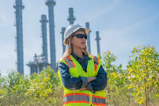 istock Industrial engineer wearing safety helmets and vests inspection technical plan and data on tablet with tall refinery towers rise background is industrial safety and carbon credit environment operations concept. 2254762761
