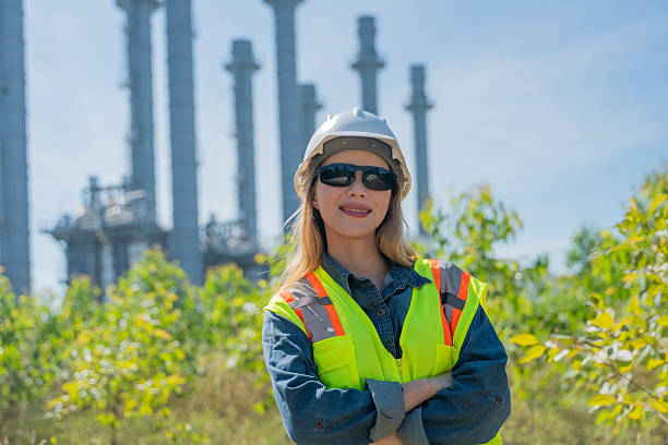 istock Industrial engineer wearing safety helmets and vests inspection technical plan and data on tablet with tall refinery towers rise background is industrial safety and carbon credit environment operations concept. 2254762772