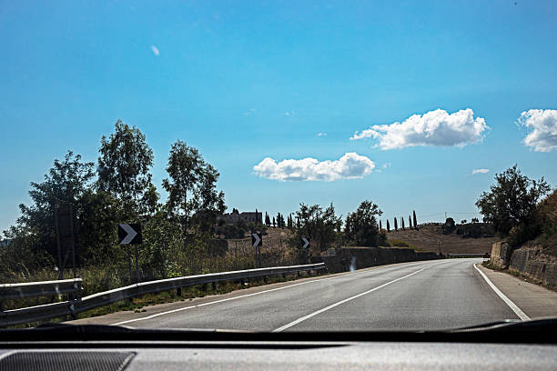Empty highway with clear skies and clouds from a car interior. Car trip