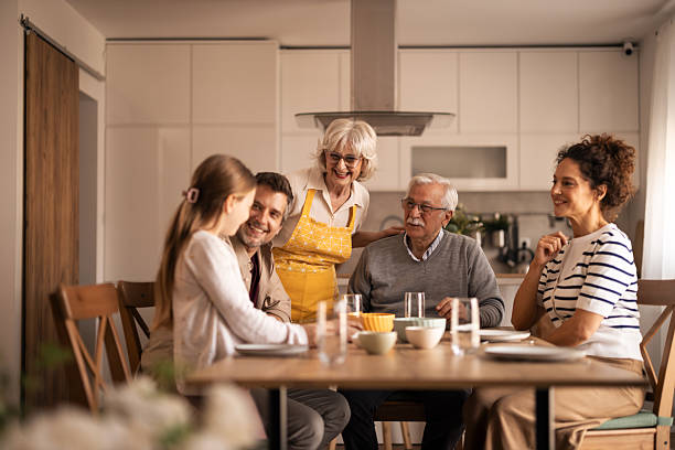 istock Multi-generational family enjoying meal sitting at kitchen table 2254765235