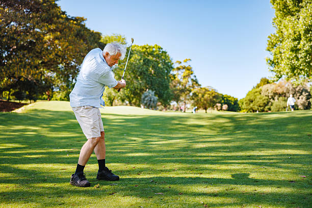 istock Elderly Caucasian Man Swinging Golf Club on Sunny Course 2254768483