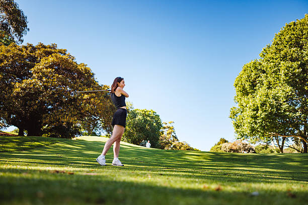 istock Caucasian Female Golfer Practicing Swing on Lush Fairway 2254768499