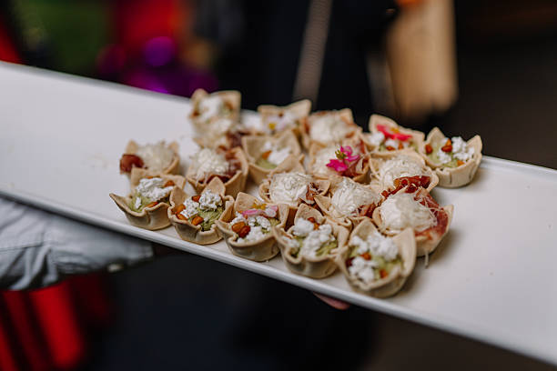 istock Assorted gourmet appetizers served on a white platter, featuring delicate pastry cups filled with fresh ingredients and garnished with vibrant edible flowers, ideal for elegant events 2254769074