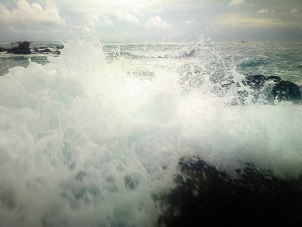Dark cliffs on coast of Indian ocean and storm surges in haze. Powerful waves very close