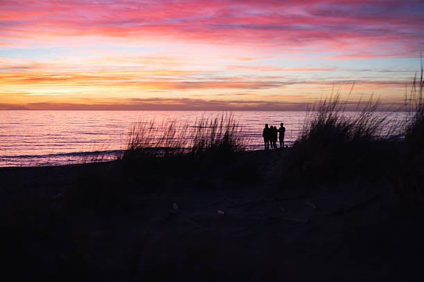 Silhouette in the evening light of people playing in the sea at a public beach