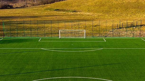 istock Wide football training field with artificial turf and distant goal, clean open space 2254771803