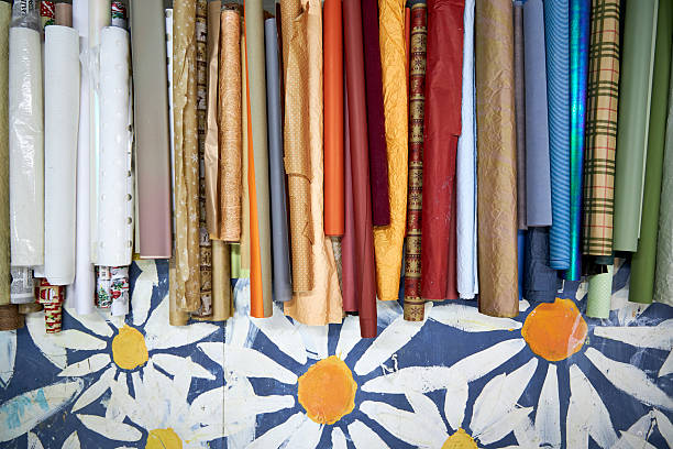 istock Colorful rolls of wrapping and craft paper neatly arranged on a creative workshop table. Artistic workspace with decorative materials, texture variety, and post-holiday gift wrapping supplies 2254772311