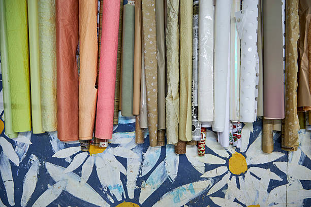 istock Colorful rolls of wrapping and craft paper neatly arranged on a creative workshop table. Artistic workspace with decorative materials, texture variety, and post-holiday gift wrapping supplies 2254772370