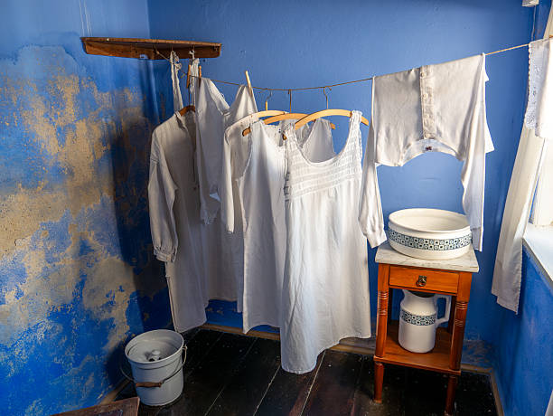 Interior of laundry room with washed garments hanging to dry in former residential house at Farvergaarden museum in old town Ebeltoft, Jutland, Denmark