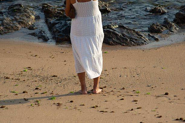 Happy woman having fun while bending over backwards during her vacation on the beach. Copy space.