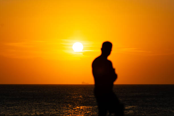 Salvador, Bahia, Brazil - January 2, 2026: Person, in silhouette, during the sunset on the horizon of the sea in the city of Salvador, Bahia.