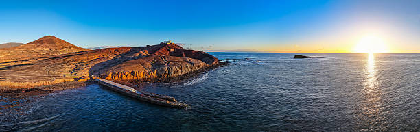 Atlantic Wellness Hub: Cinematic Aerial of the Muelle Viejo Swimming Platform and Tidal Sunbathing Deck on the Volcanic Shoreline of Arinaga, Gran Canaria, Spain
