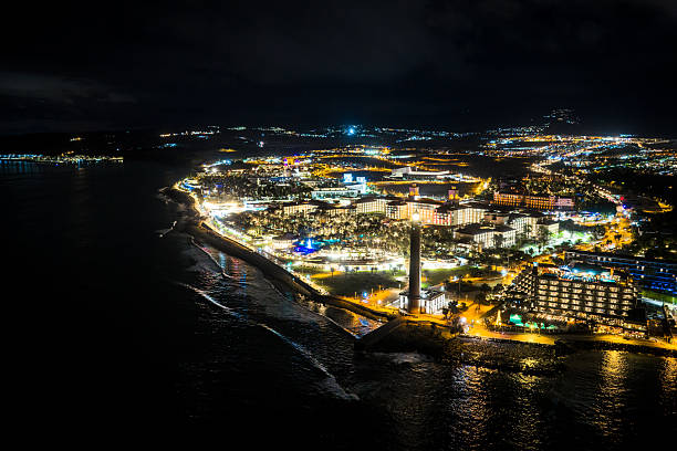 Aerial view of Maspalomas at Night -  Faro de Maspalomas Lighthouse, El Oasis Palm Grove, and the Elite 5-Star Resort Strip of Meloneras, Gran Canaria, Spain