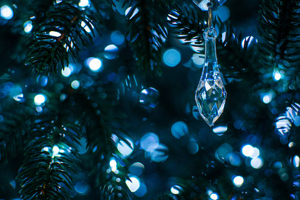 Elegant Crystal Ornament on Lit Christmas Tree Branches with Festive Bokeh Effect