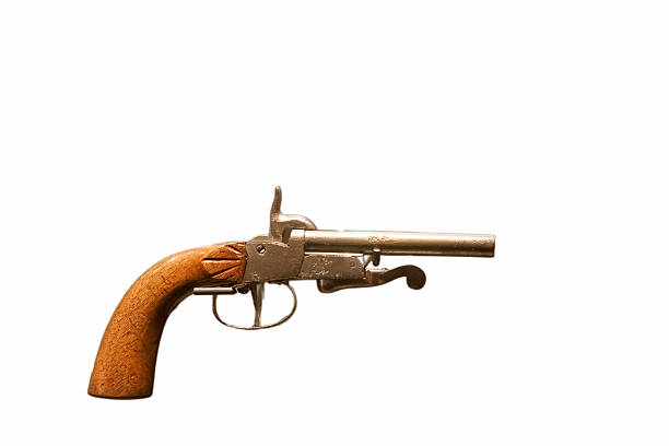 A historic pistol features a finely made wooden handle. The metal barrel is prominently visible, reflecting its antique design. This piece highlights the artistry of weapon craftsmanship.