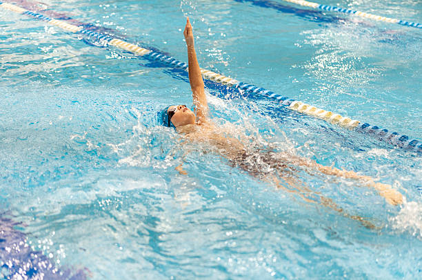 Adolescent girls swimming backstroke in a very competitive race at an outdoor swim meet.________________________________________Please see my competitive swimming lightbox here: